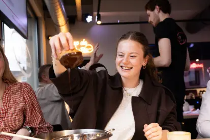 Vrouw met Bossche bol in de chocolade